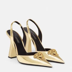 Gold high-heeled shoes with decorative embellishments on a white background