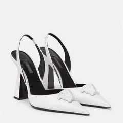 White high-heeled shoes with black accents on a white background